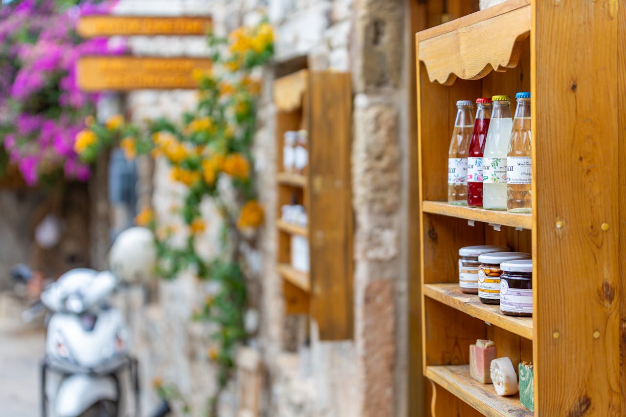 our-services-2 Charming street shelf with bottles and jars, next to a quaint brick alleyway.