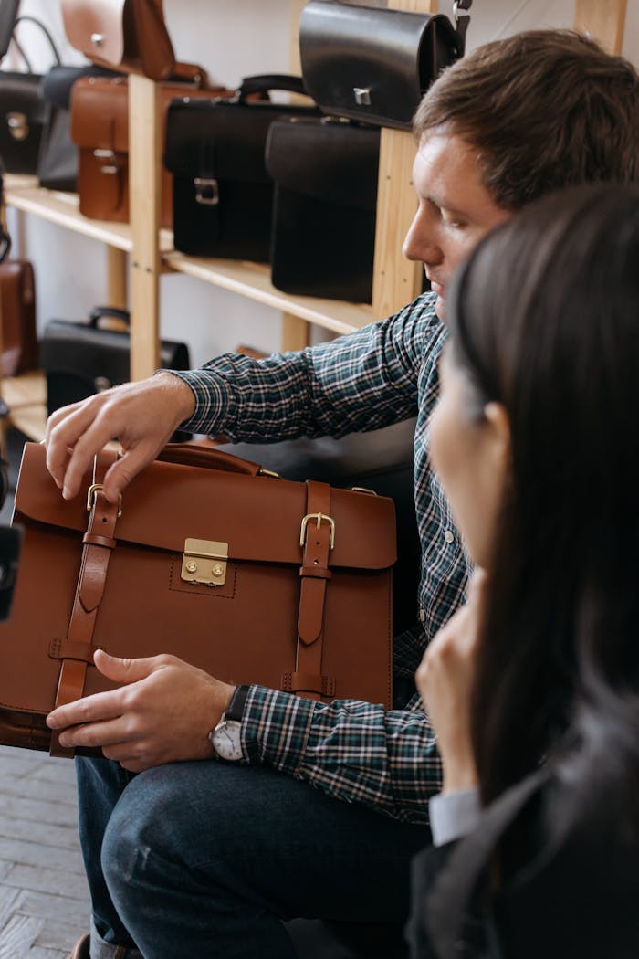why-choose-us A man sits indoors examining a stylish leather briefcase in a store setting.