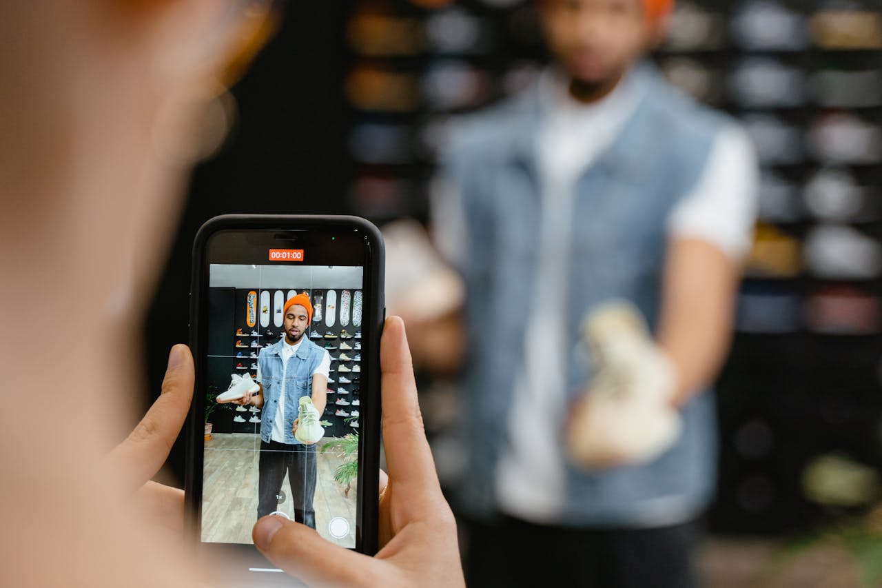 services-img Man reviewing sneakers in-store captured on smartphone, showcasing footwear.